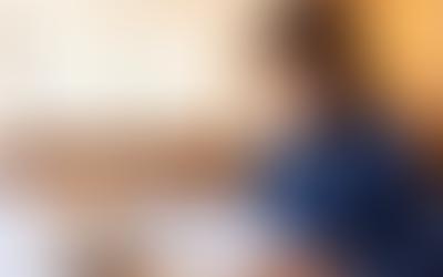 A focused professional reviews documents while working on a laptop in a modern office setting, embodying concentration and productivity.