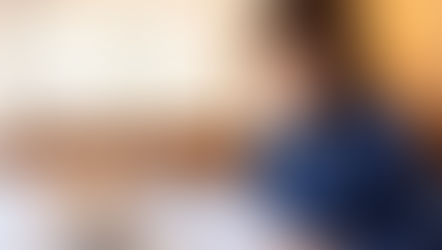 A focused professional reviews documents while working on a laptop in a modern office setting, embodying concentration and productivity.