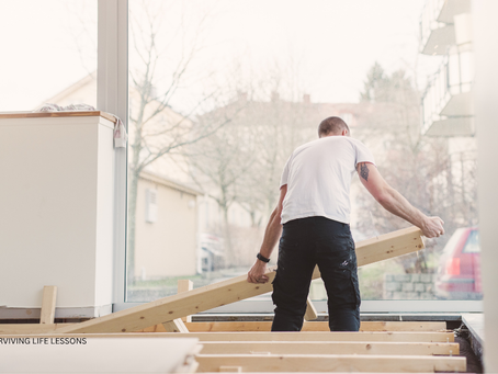 A man lifts a wooden beam, symbolizing starting over and rebuilding.