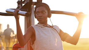 A woman exercises outdoors under the sunlight.