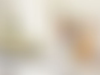 A woman sits at her desk in an office, leaning back in her chair with her arms open and eyes closed, expressing relief and empowerment as she breaks free from people-pleasing and reclaims her sense of self.