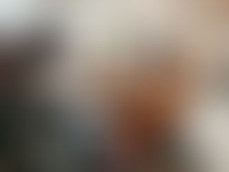 A group of four people sitting together with paper and pens, engaged in an energetic conversation and sharing ideas.