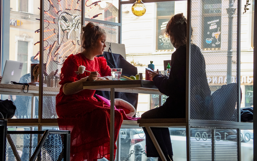 A supervisor talking with an employee at a breakroom table, both looking emotionally tired but engaged in conversation