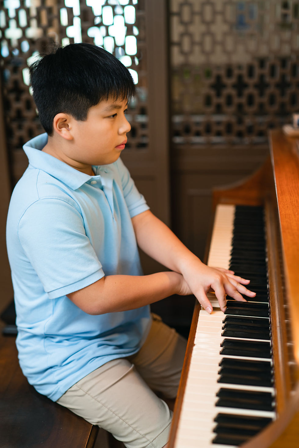 Focusing intently while practicing at the piano, immersing himself in the music.
