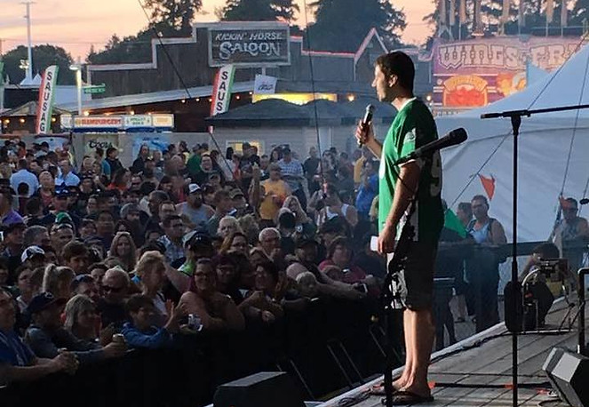 Joel tells jokes in front of a massive crowd of thousands at the Saskatoon Ex Grand stand.