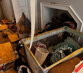 Cluttered room with dirty playpen and debris on floor