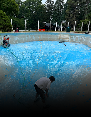 Worker maintaining an empty blue pool