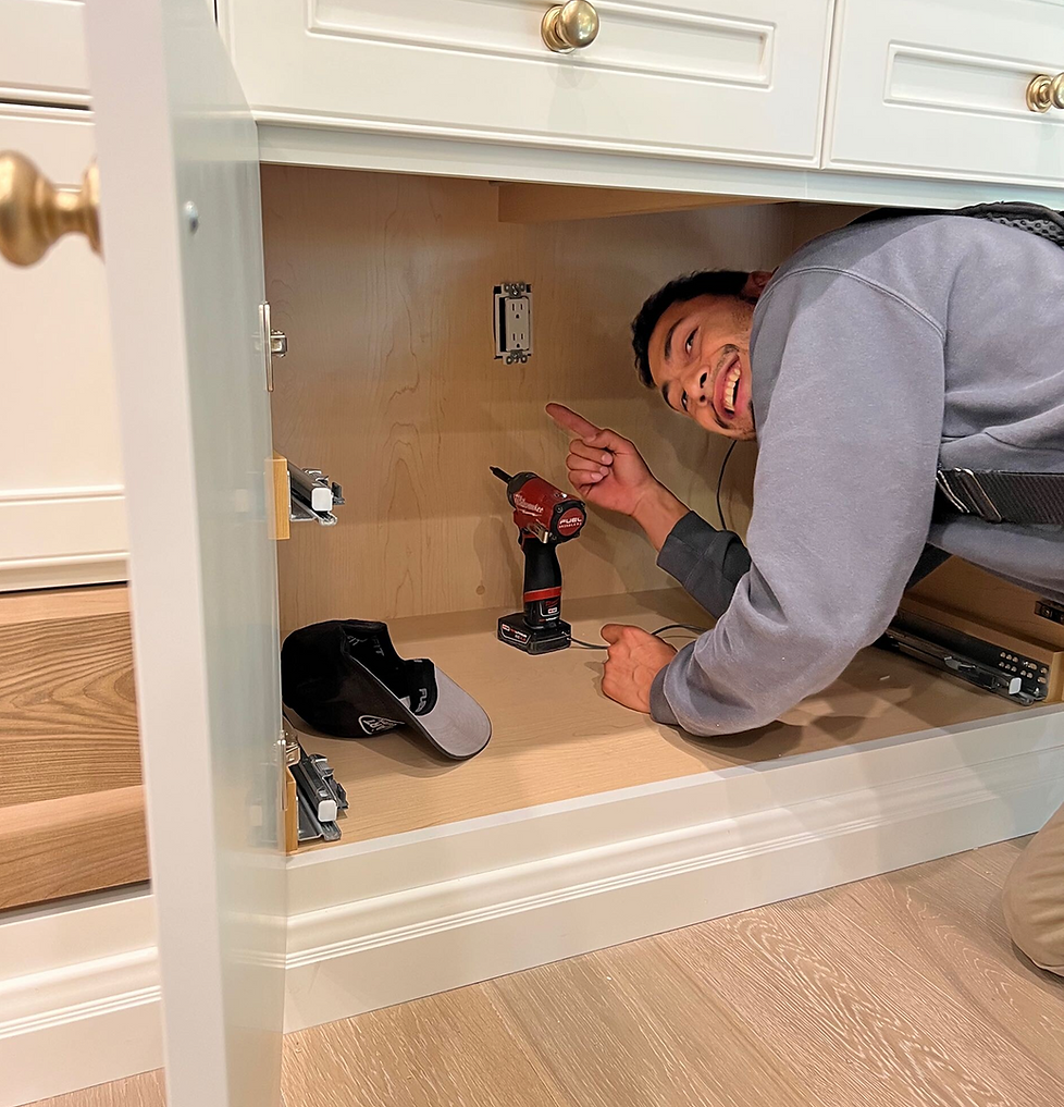 Man smiling, pointing at drill inside new cabinet