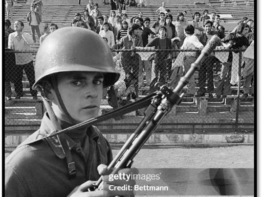 A military guard in front of a crowd of men.