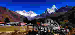 Huge snow mountains in the background and small houses in front