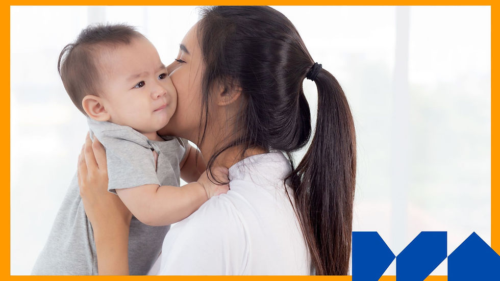 Woman with long hair kisses a baby in a gray shirt, who looks puzzled. Bright, light background with orange border and blue shapes.