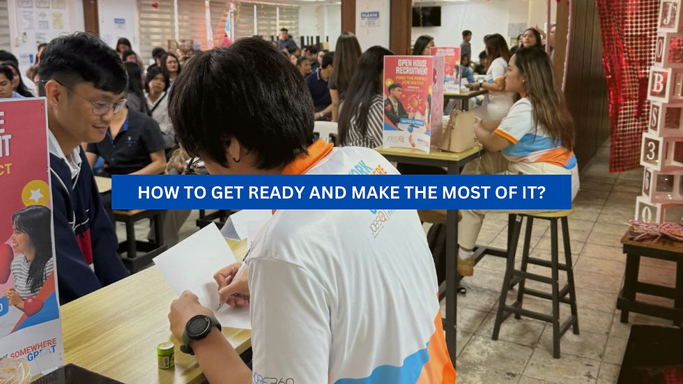 People at a recruitment event, sitting at tables, engaged in discussions. Posters and signs, including "Open House Recruitment," are visible.