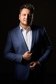Fotografia biznesowa Rzeszów- Mężczyzna w garniturze na czarnym tle-
