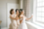 Bridesmaids helping bride into gown at The Pfister Hotel in Milwaukee, Wisconsin.