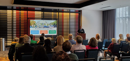 City Manager presenting at a podium in front of event attendees
