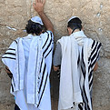 A man and his son pray at the Western Wall while celebrating the son's bar mitzvah