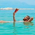 A man on a private tour of Israel floats on his back in the Dead Sea while reading a book