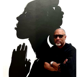 side profile of african american woman with hands in prayer. Artist sitting in front of the portrait