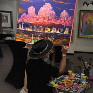 man drawing las vegas skiline with mountains behind it and huge clouds rising up behind mountains