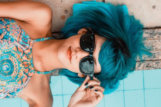 photo couleur d'une personne avec une perruque bleue et des lunettes de soleil