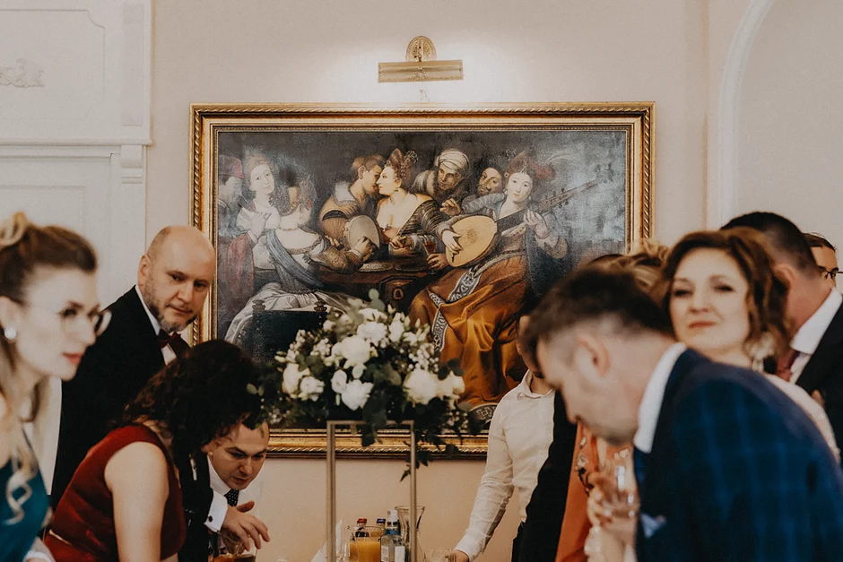 lenerowa ceremonia pod błękitnym niebem, wejście Pary Młodej wśród kwiatów, ikoniczny Cadillac Sedan DeVille przed pałacem, pałacowe wnętrza pełne blasku.