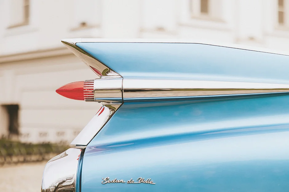 lenerowa ceremonia pod błękitnym niebem, wejście Pary Młodej wśród kwiatów, ikoniczny Cadillac Sedan DeVille przed pałacem, pałacowe wnętrza pełne blasku.