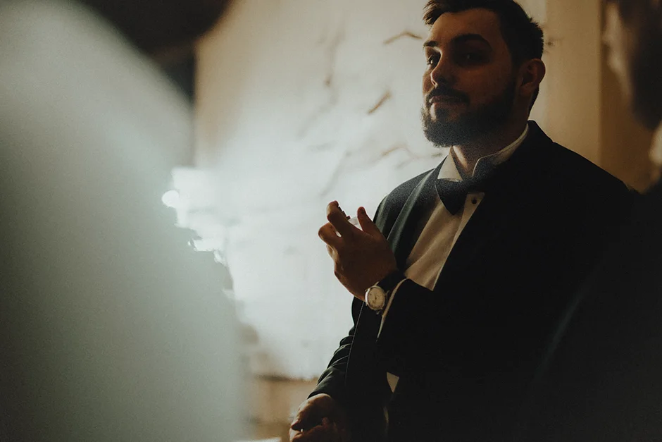 Adam w eleganckim garniturze szykuje się do ślubu, otoczony rodziną