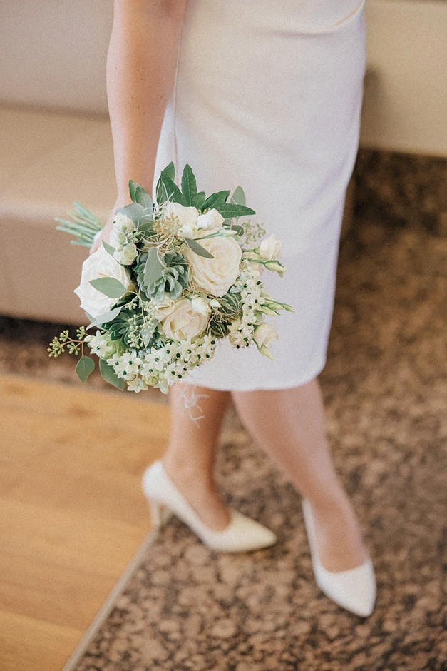 Bukiet ślubny Panny Młodej, pełen świeżych kwiatów.