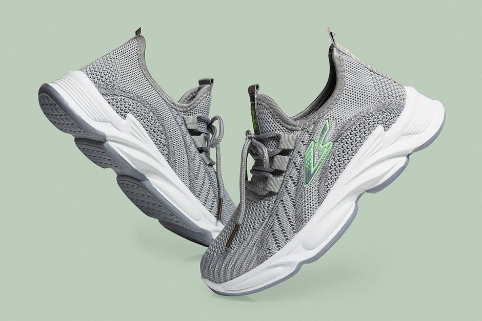 Para nowoczesnych sneakersów ustawiona centralnie na intensywnie niebieskim tle, miękkie światło podkreśla fakturę skóry i detale podeszwy.