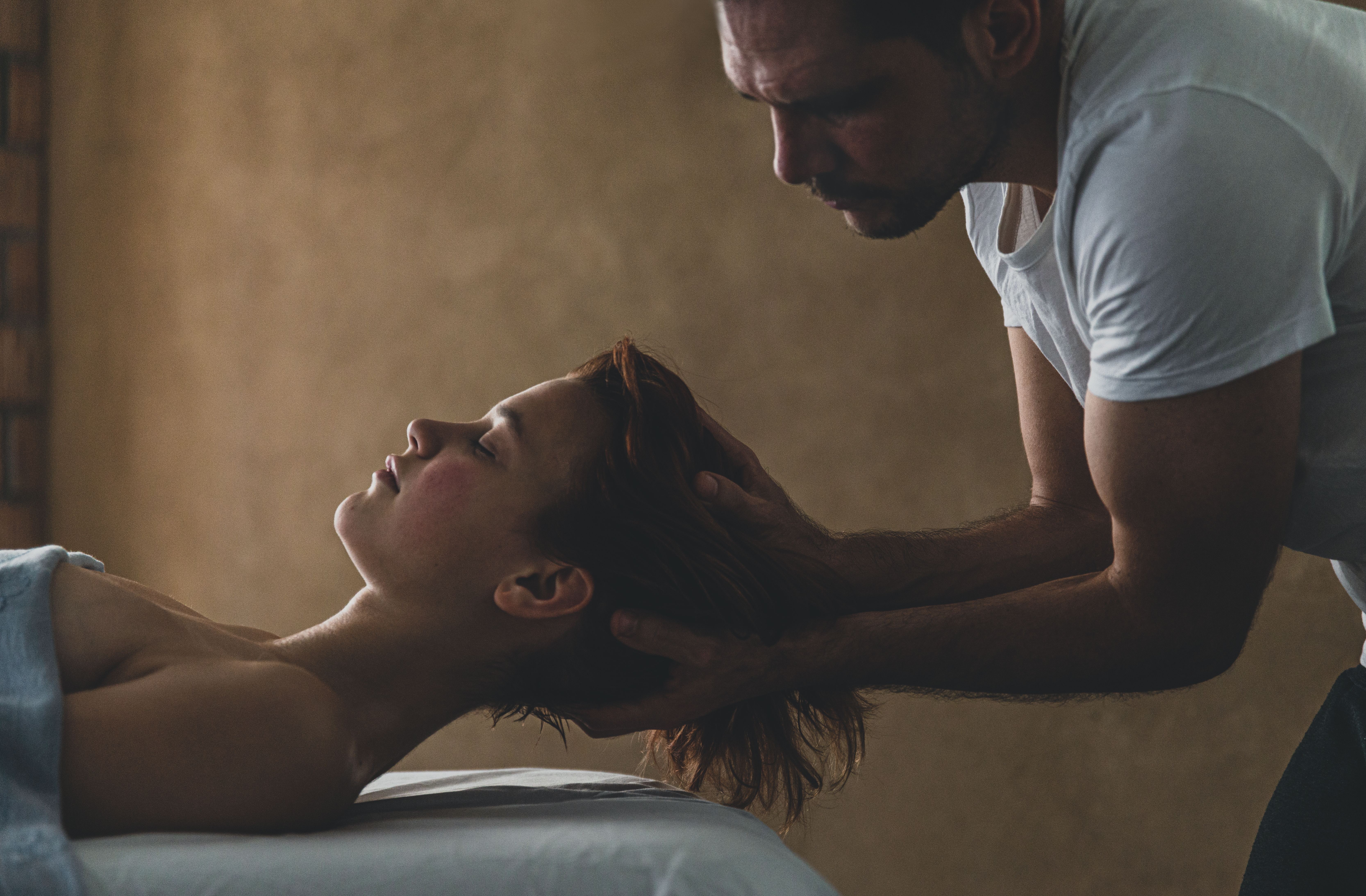 Woman relaxed receiving a head massage in a cosy room