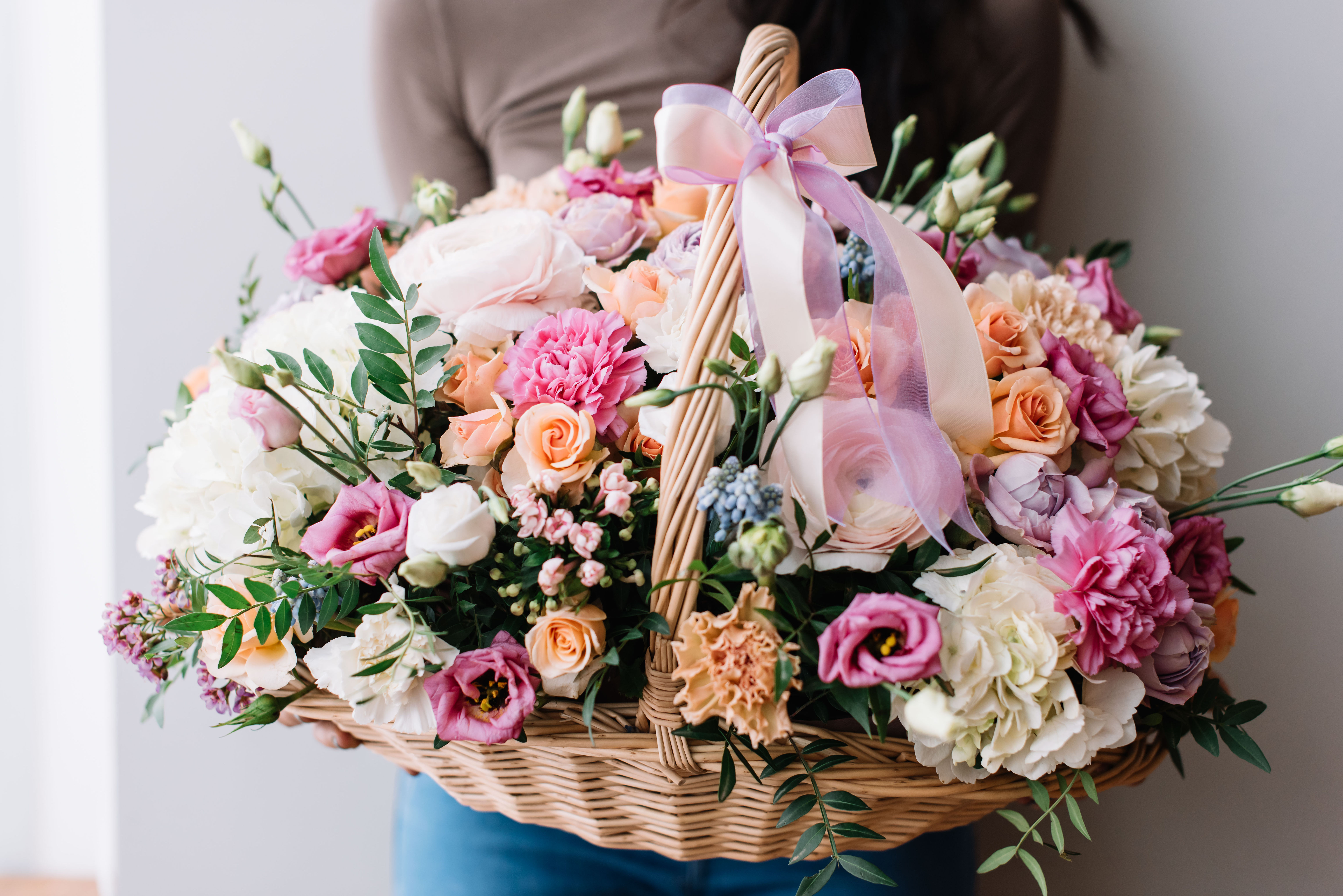 סל-פרחים-גדול-עם-מגוון-פרחים-בהירים-ופסטליים-כולל-ורדים-דלעתים-ופרחי-קרן-הזהב-קשור-בסרט-סאטן-משולב-בדוגמאות