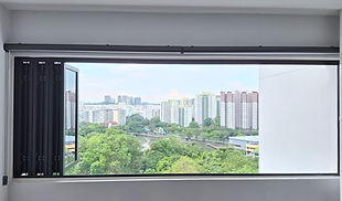 Fully opened black aluminium folding window in HDB flat, offering panoramic city view and ventilation — also known as bifold or bifolding window system.