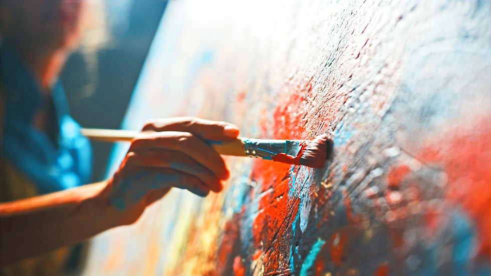 Un peintre peint une toile avec un pinceau plein de couleurs