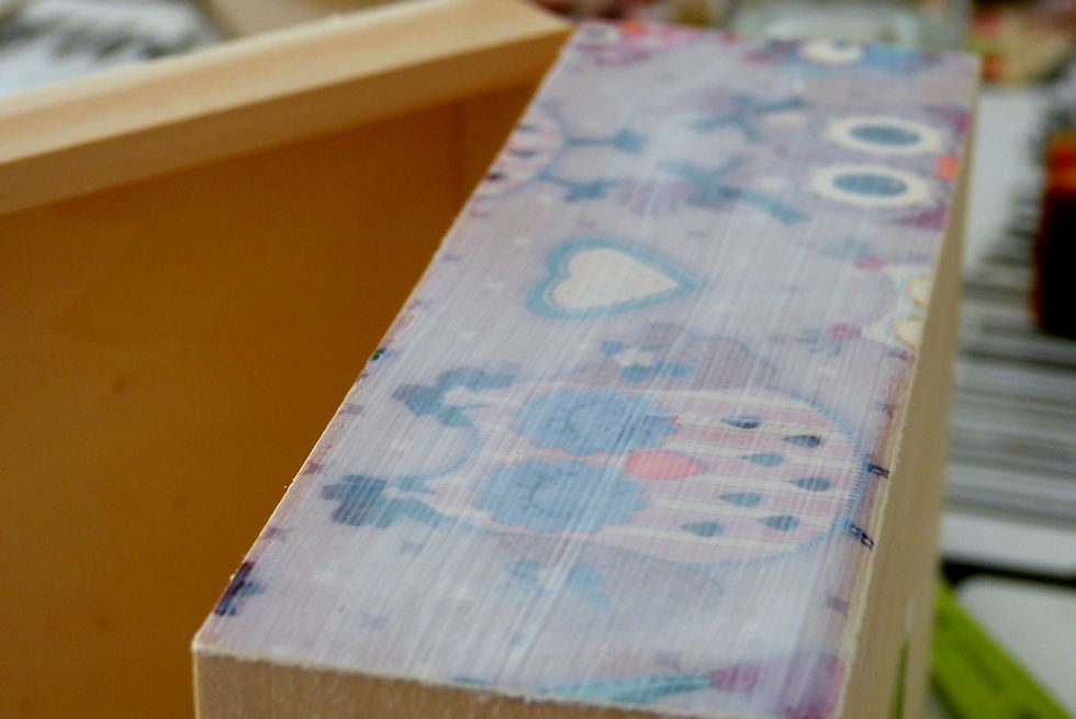 Una vez que pegas el papel a la caja, puedes darle otra mano de cola decoupage sobre el papel para mejorar el resultado.