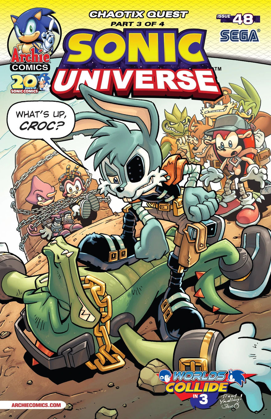Jack Rabbit rests one foot on Vector’s chest, who lies on the ground with his eyes closed. In the background, Espio and Charmy are chained to a rock, while Mighty watches worriedly, surrounded by members of the Sand-Blasters in a sandy setting.