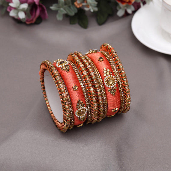 Peach silk thread bangles with gold accents