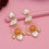 Thumbnail: Elegant gold earrings with orange and pearl accents