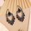 Thumbnail: Black crystal drop earrings with intricate detailing