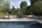 Pool und Gartenanlage mit Natursteinboden, Natursteintreppe, rustikler Naurstein Mauer und Bodenplatten im Pool