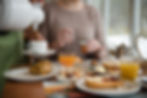 Frühstück: Kaffee wird eingeschenkt, Ei wird geöffnet, Brötchen und Müsli