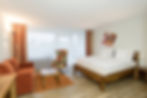 Gemütliches Hotelzimmer mit Doppelbett, Sofa und Sessel