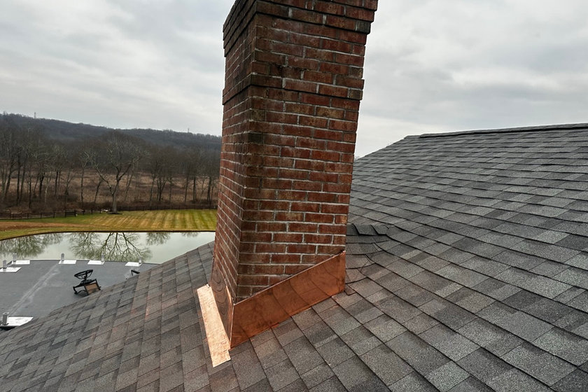 Step flashing rebuilt around a brick chimney during a roof replacement in Nutley NJ