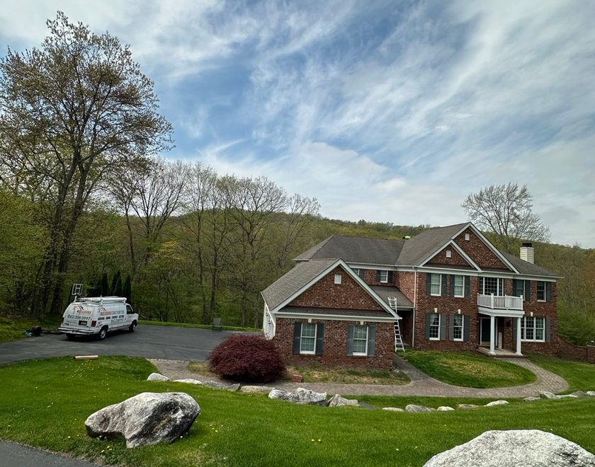 Roofer inspecting a shingle roof during a free Paramus NJ roof repair estimate