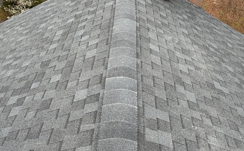 Crew repairing a brick chimney at the roofline in Nutley NJ