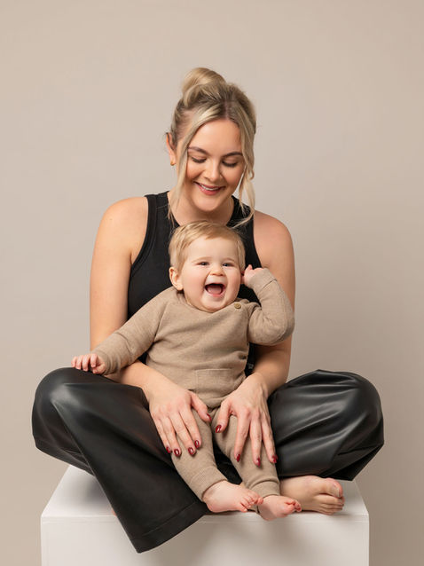 Parent sitting with baby during a relaxed studio photography session