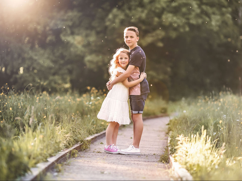 siblings-standing-together-looking-at-oudoor-photographer-in-leicester.jpg