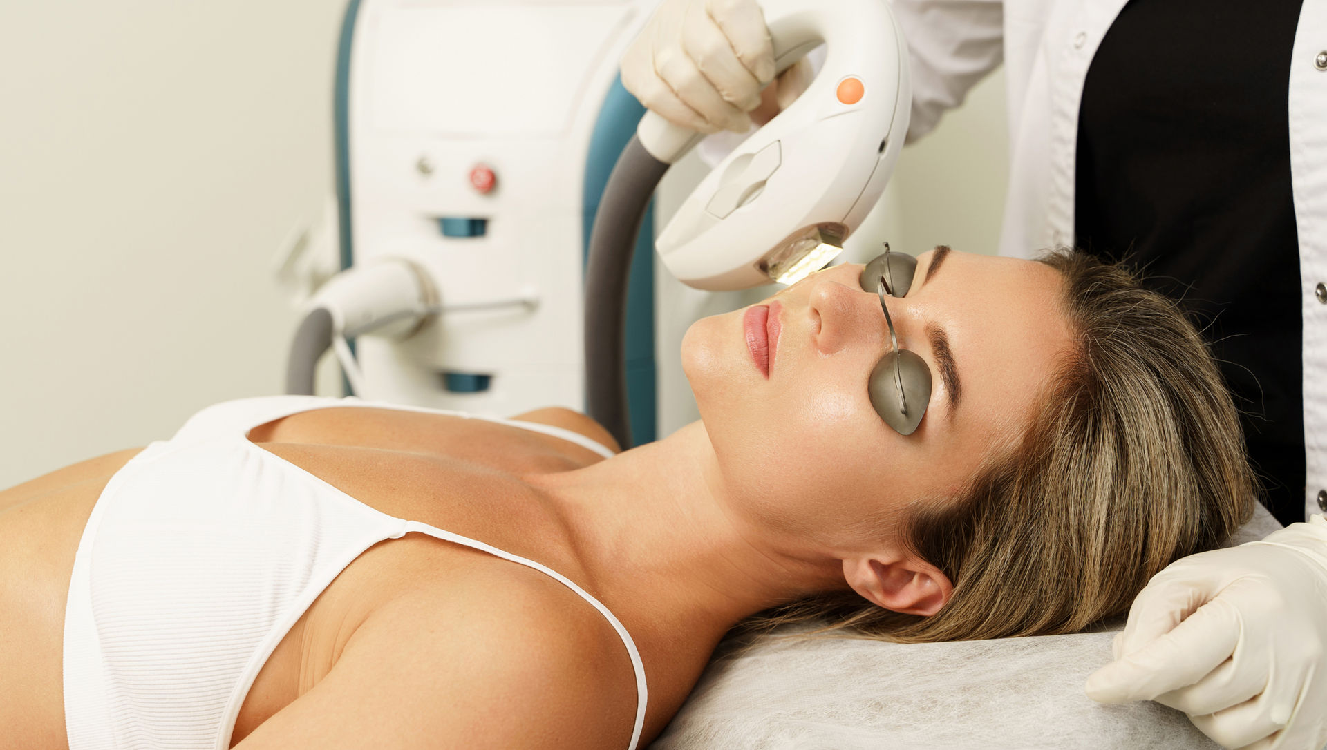 Woman laying down with eye protection, receiving IPL treatment