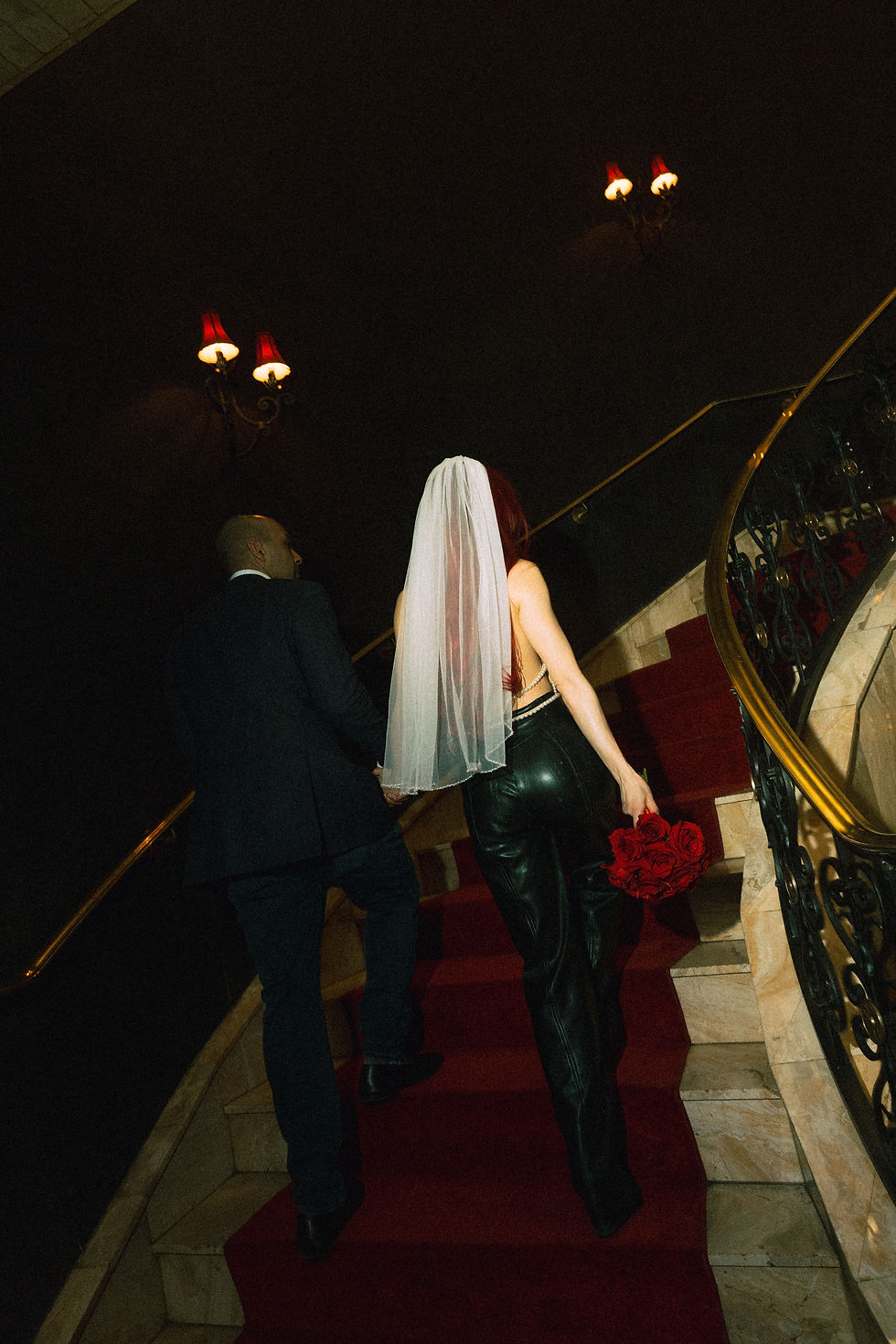 Bride and groom walking up red carpet staircase at El Cortez during Las Vegas Fremont Street elopement