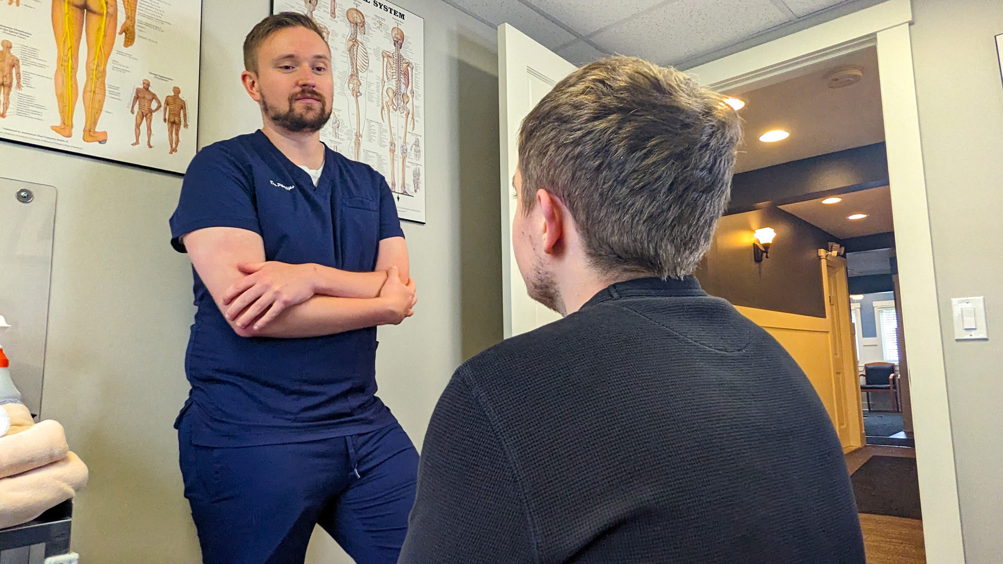 IronChiro chiropractor discussing a student athlete's in-season recovery plan during an evaluation