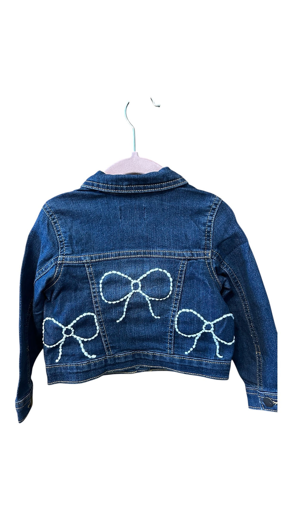 Denim jacket for kids featuring a cute bow design on the back, adding a playful touch to any outfit.